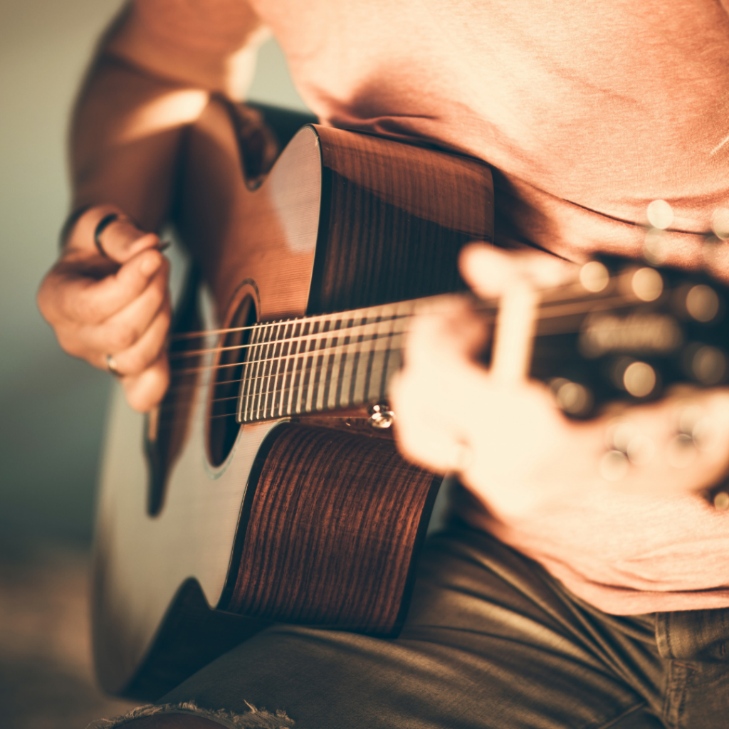 Man strumming a guitar, balled music examples